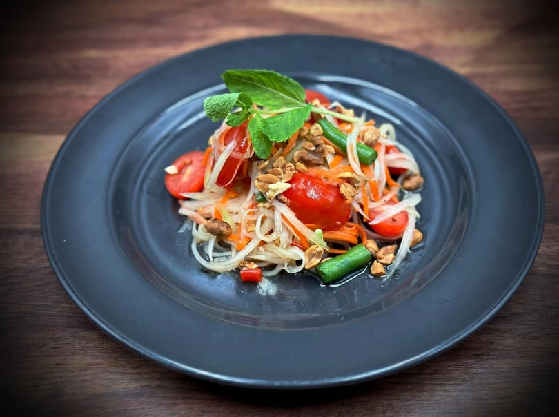 Som Tum, a Thai green papaya salad with tomatoes, green beans, and peanuts.